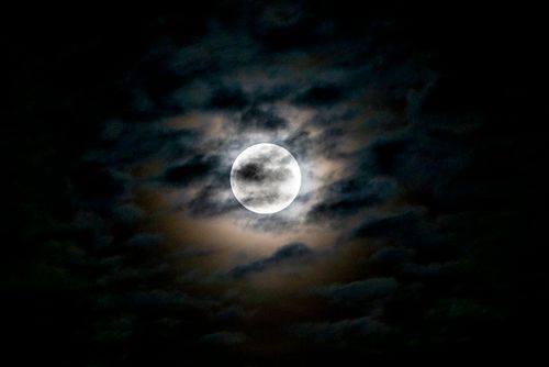 Free A stunning full moon peeks through dark clouds in a dramatic night sky in Huntsville, AL. Stock Photo