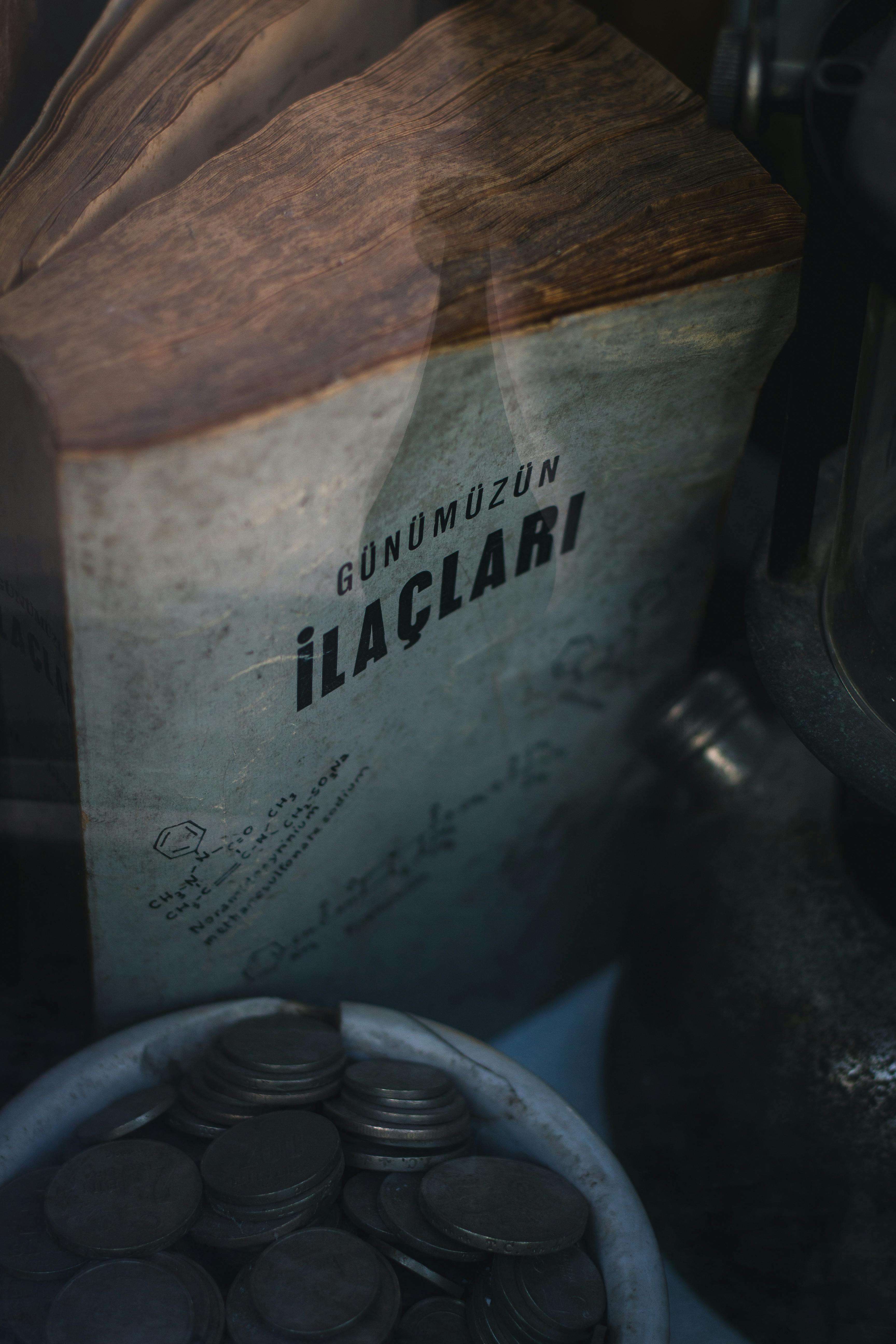 Close-up of an antique book with coins, featuring a moody, vintage aesthetic.