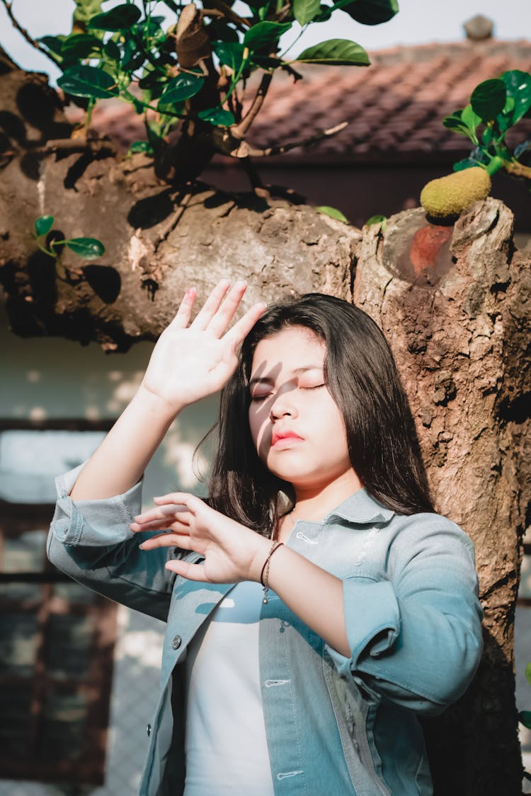 A Woman Blocking The Sun With Her Hands