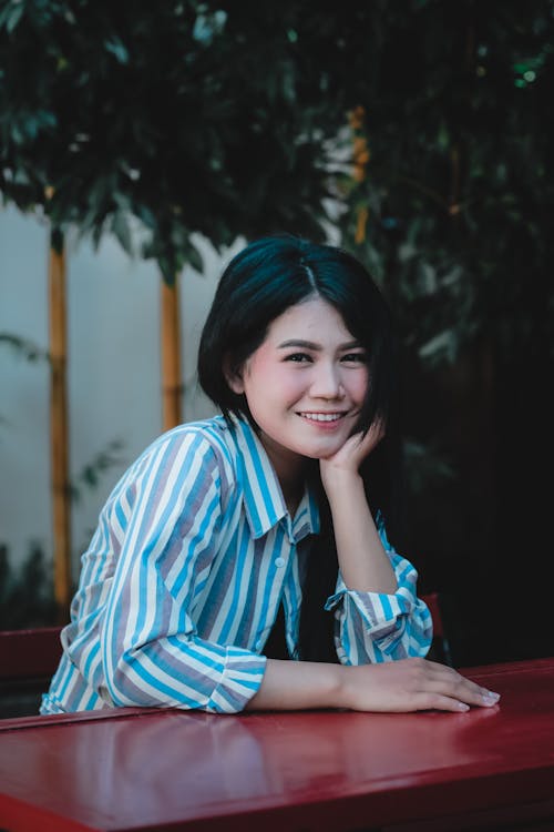 Portrait of a Woman in a Striped Shirt with Her Hand on Her Chin