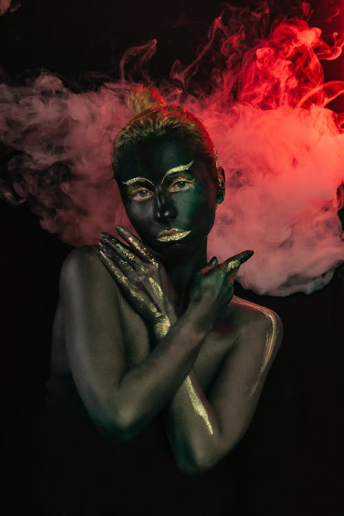 Woman with black paint on body and face and golden makeup