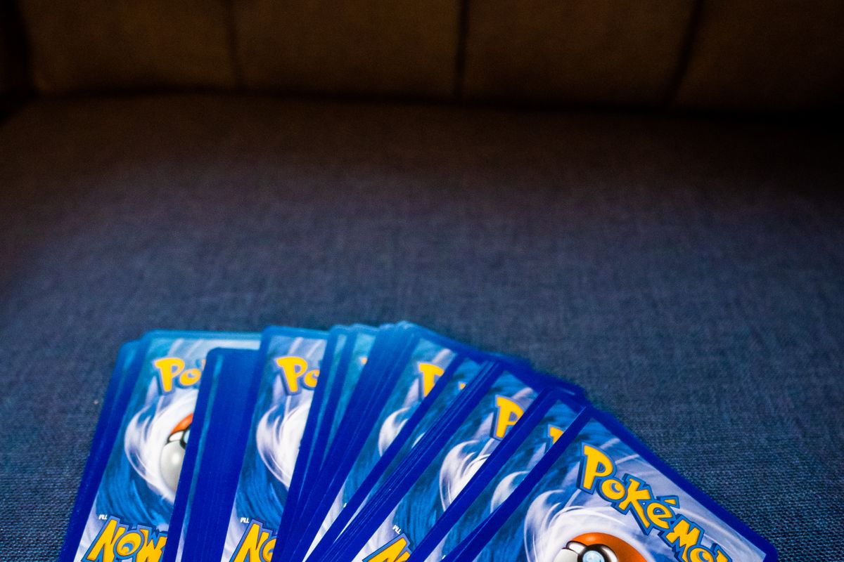 Pokémon cards fanned out on a sofa, ready to be sorted and valued