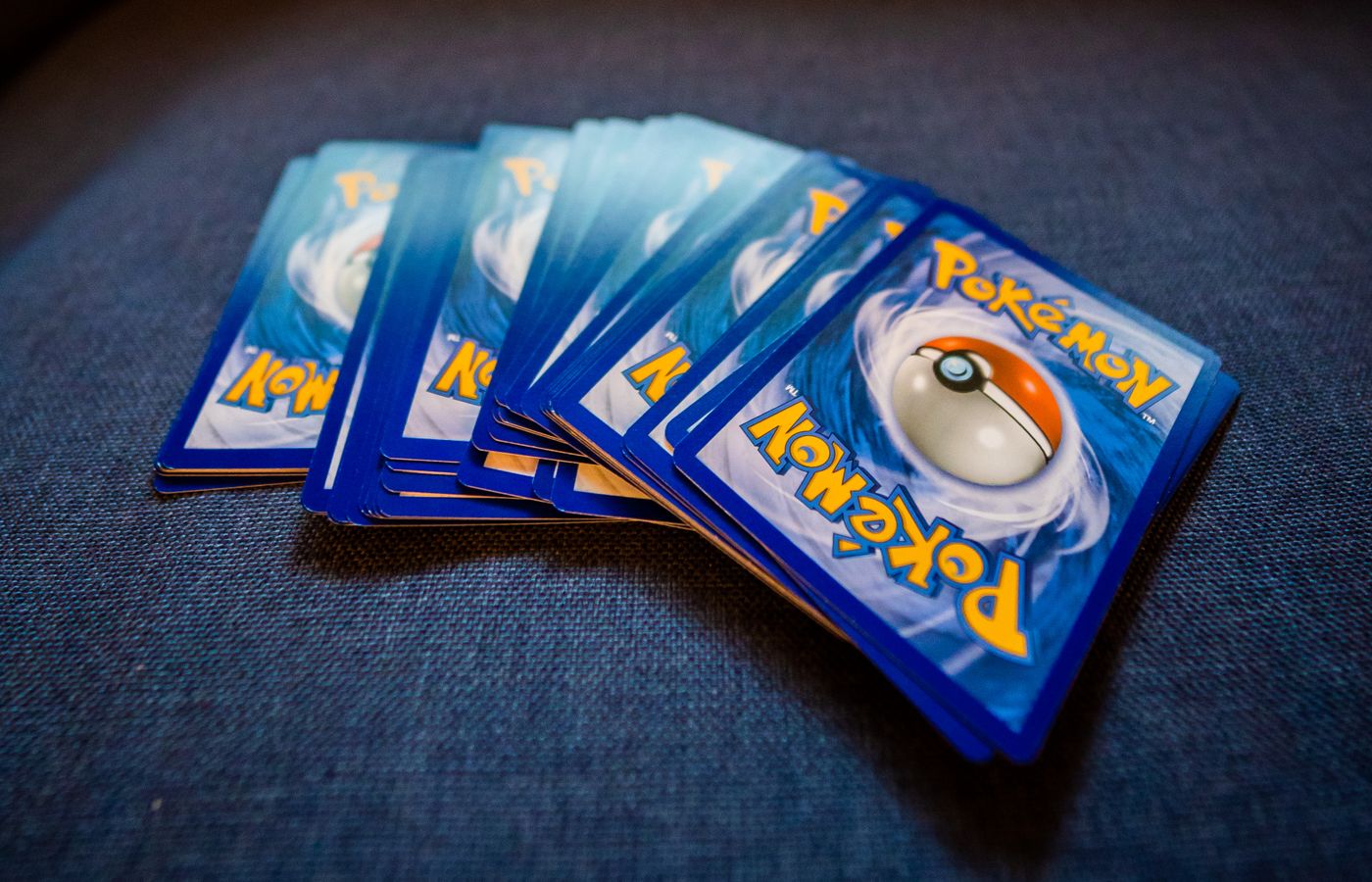 A set of Pokémon cards displayed on a blue surface, perfect for game enthusiasts.