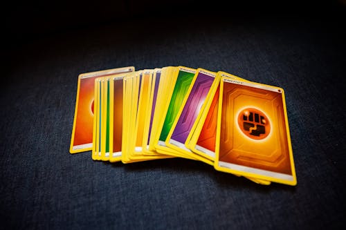 From above of colorful pack of trading cards for game placed on gray surface