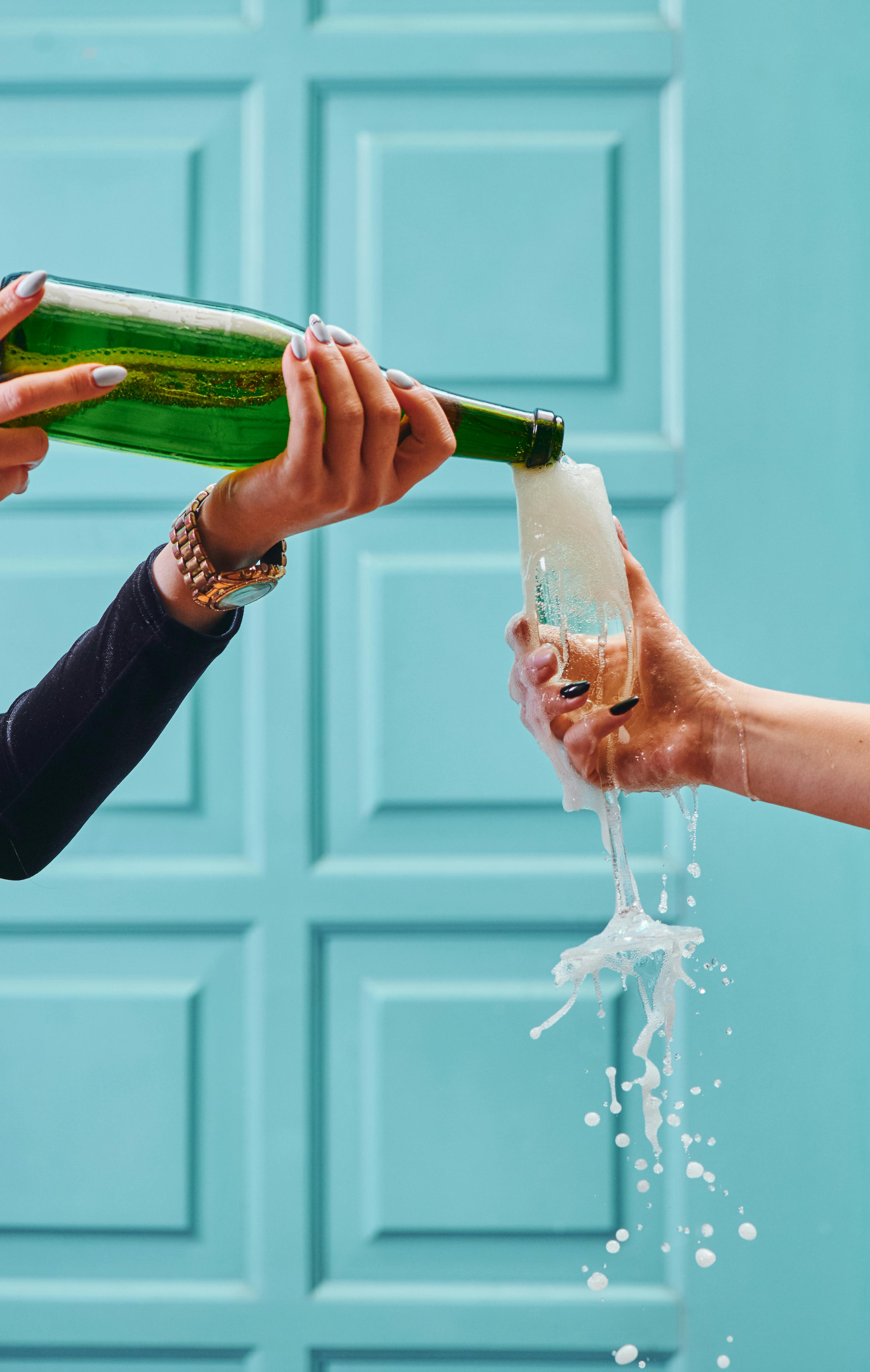 photo of a person pouring champagne into a glass