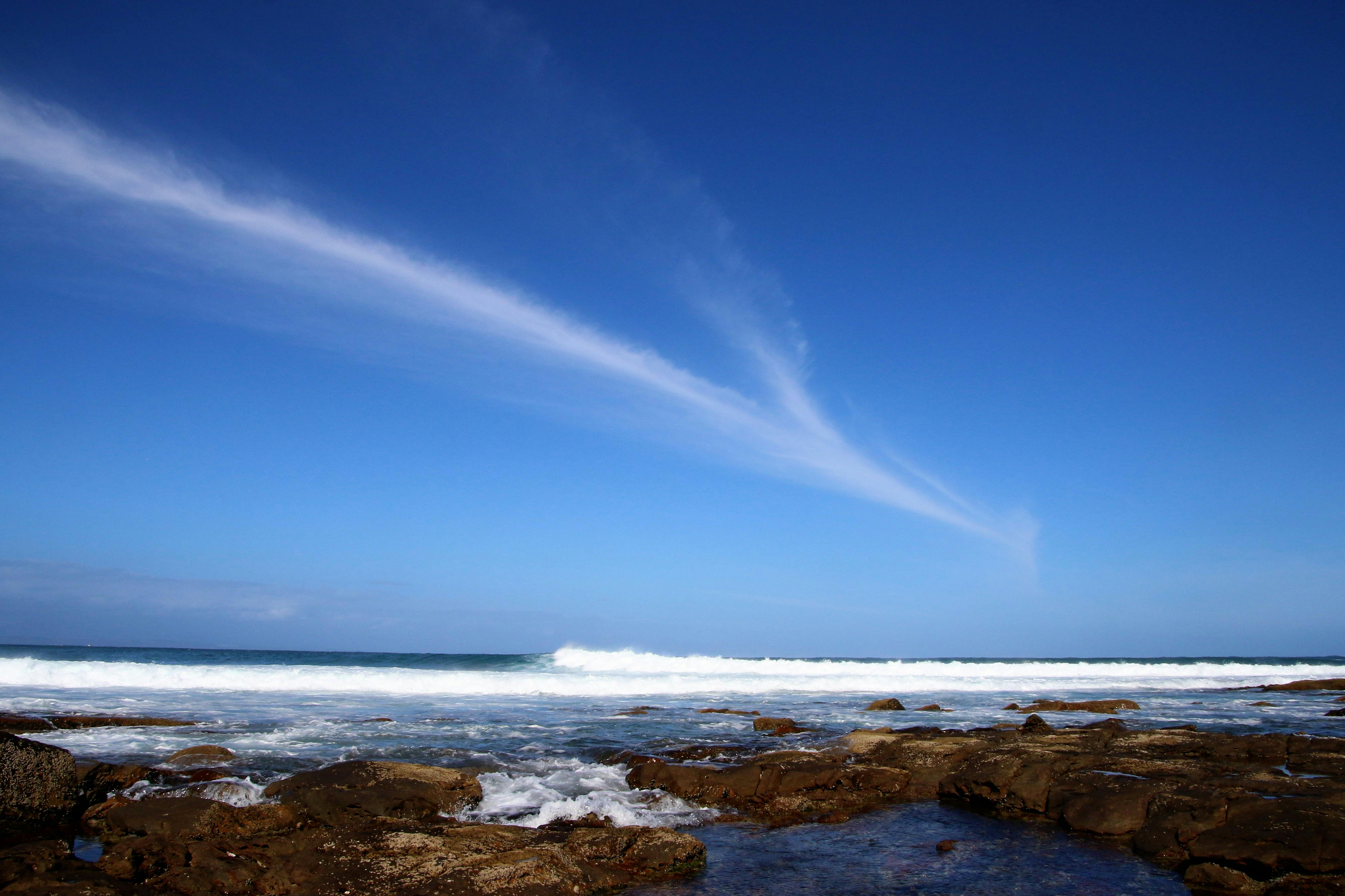 body of water under blue sky at daytime free stock photo