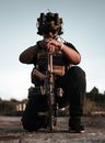 Photo of a Man Kneeling while Holding His Rifle