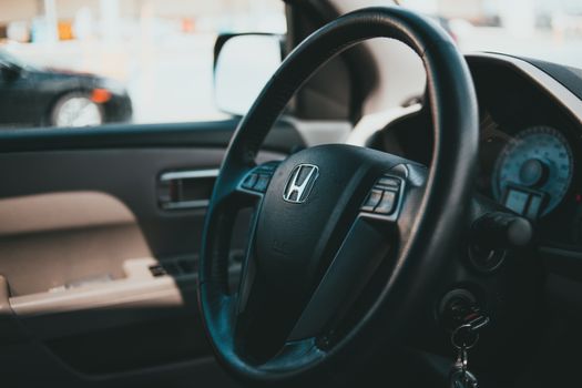 Close-up shot of a car steering wheel with dashboard, showcasing vehicle interior details.