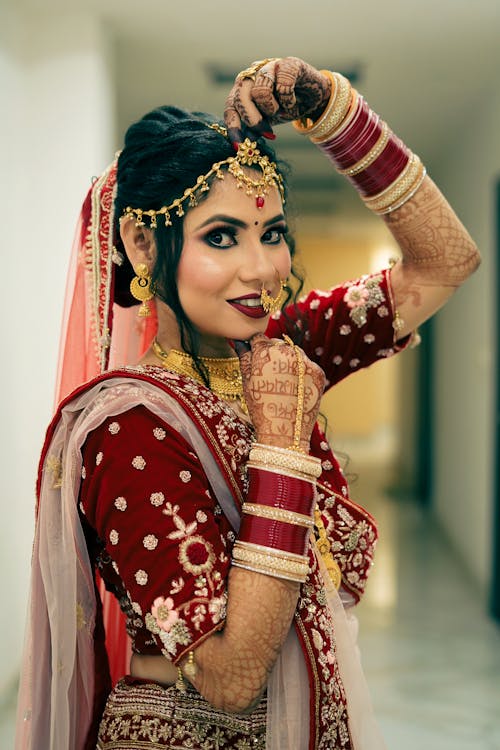 Free Photo of a Bride in Traditional Wear with Her Hand on Her Chin Stock Photo