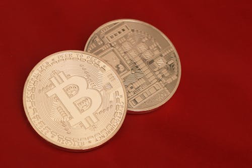 Photo of Two Coins on a Red Surface
