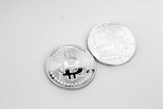 Close-up of two silver Bitcoin coins showcasing digital currency and modern finance.