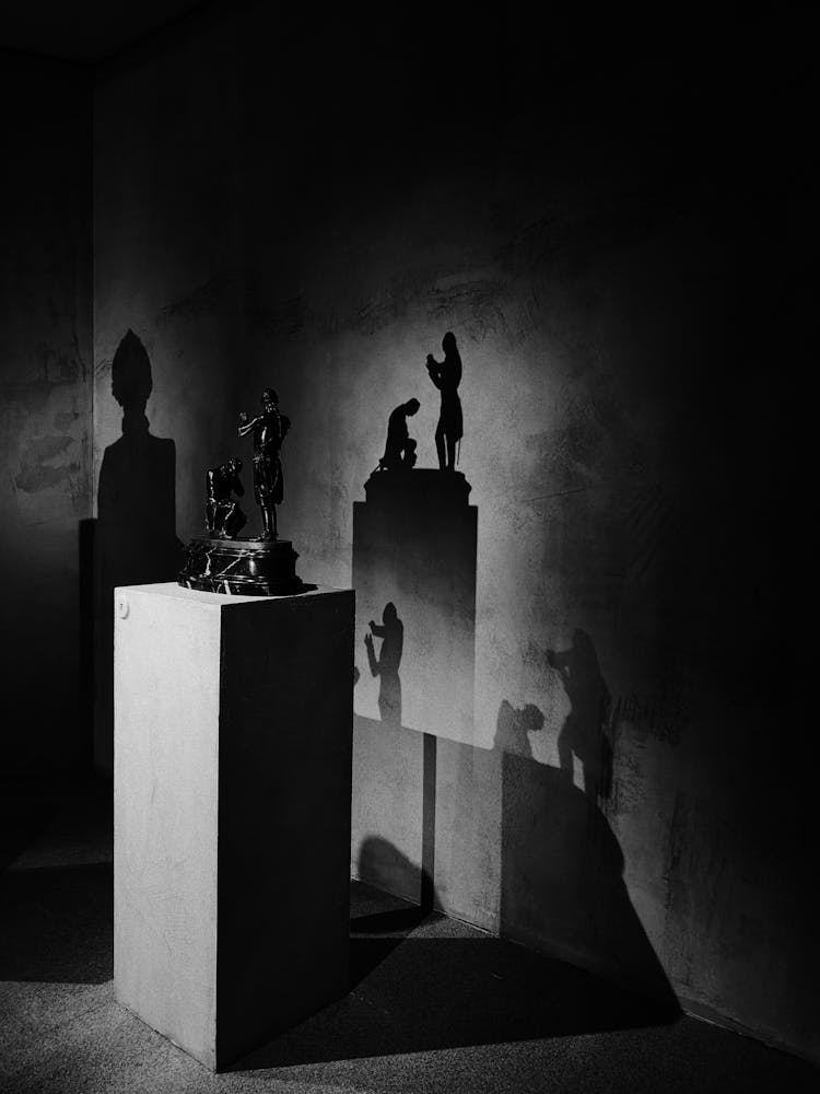 A Light Casting Shadows Of A Sculpture On A Concrete Wall