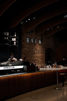 Chic coffee shop interior showcasing a barista at work behind the counter.