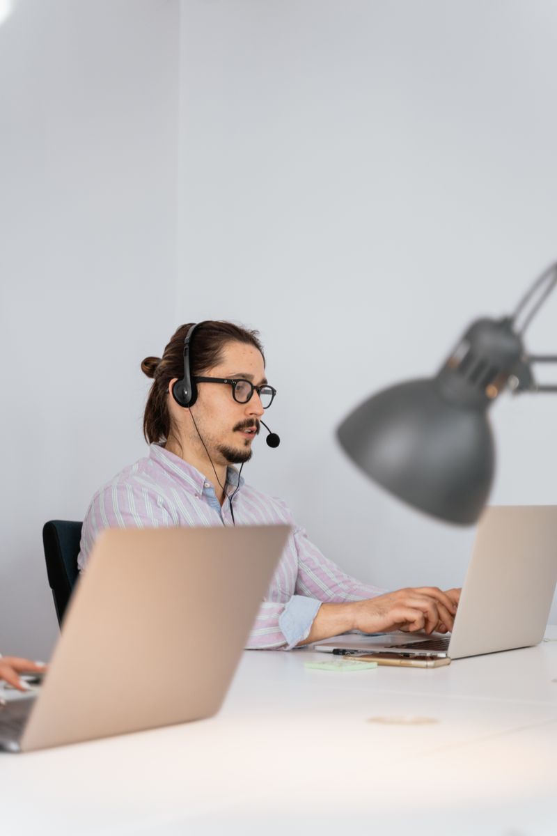 Un conseiller équipé d'un casque-micro répond au téléphone devant son ordinateur portable