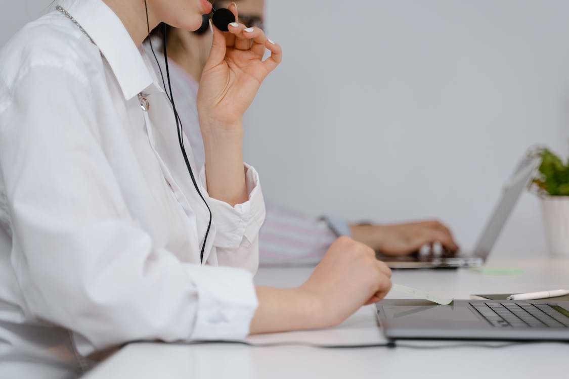 Free A Woman Talking on a Headset while Working Stock Photo