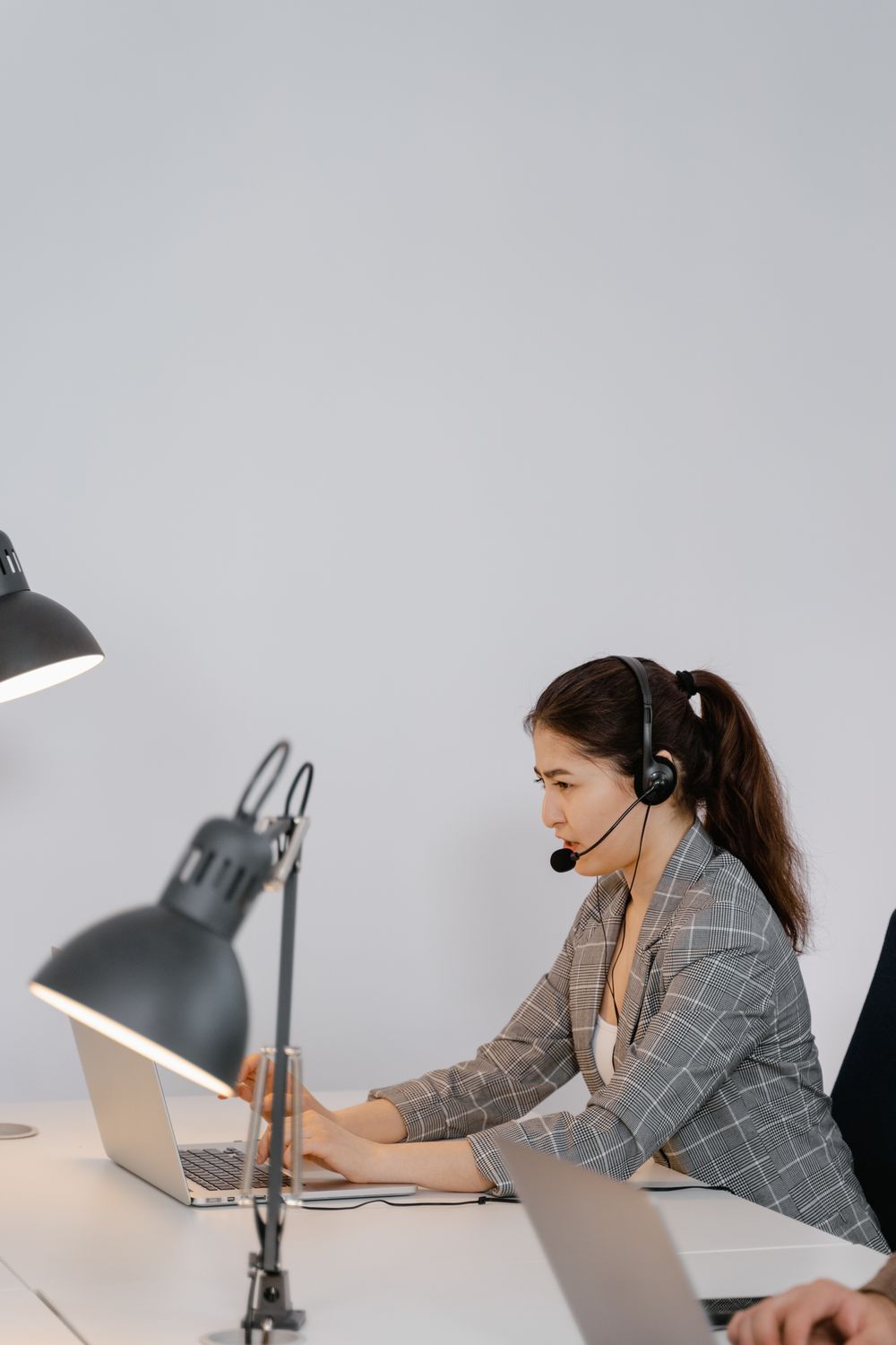 Headset-wearing professional working at a laptop