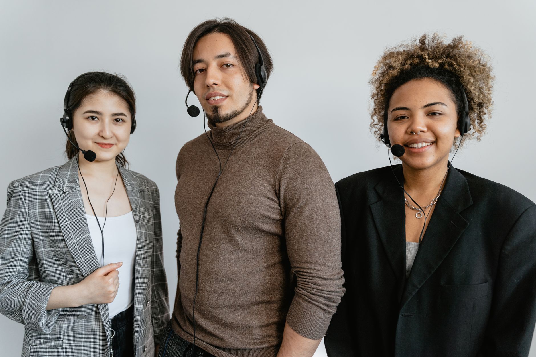 Three diverse call center employees wearing headsets, ready to assist customers.