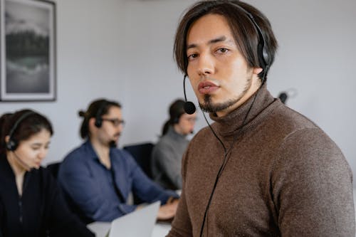 Free A Bearded Man Wearing a Brown Turtle Neck Sweater with Black Headset Stock Photo