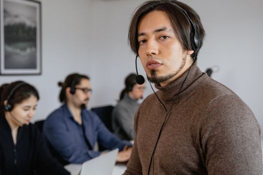 Focused call center team working attentively with headsets on in office.