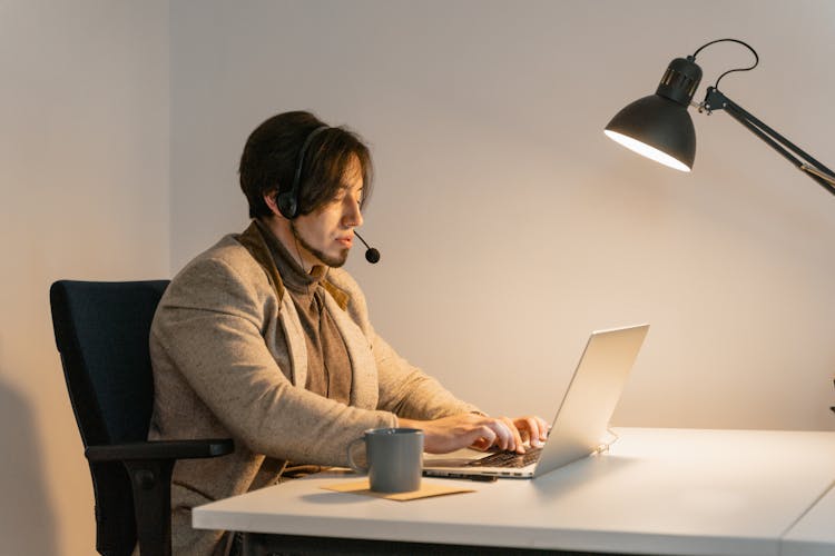 A Call Center Agent Typing On A Laptop