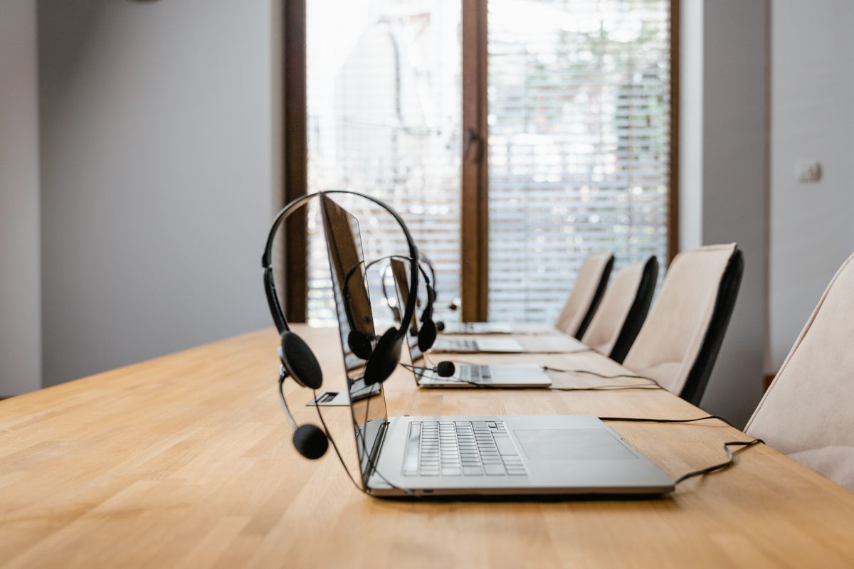 Tools and integration for your firm's size Conference table set with headsets and laptops