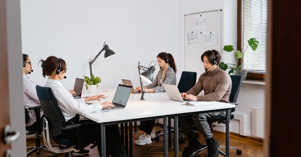 Photo by MART PRODUCTION Team of professionals working in a call center using laptops and headsets in a modern office.