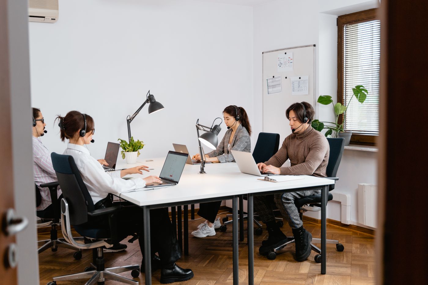 Customer service outsourcing team working with desktop computers