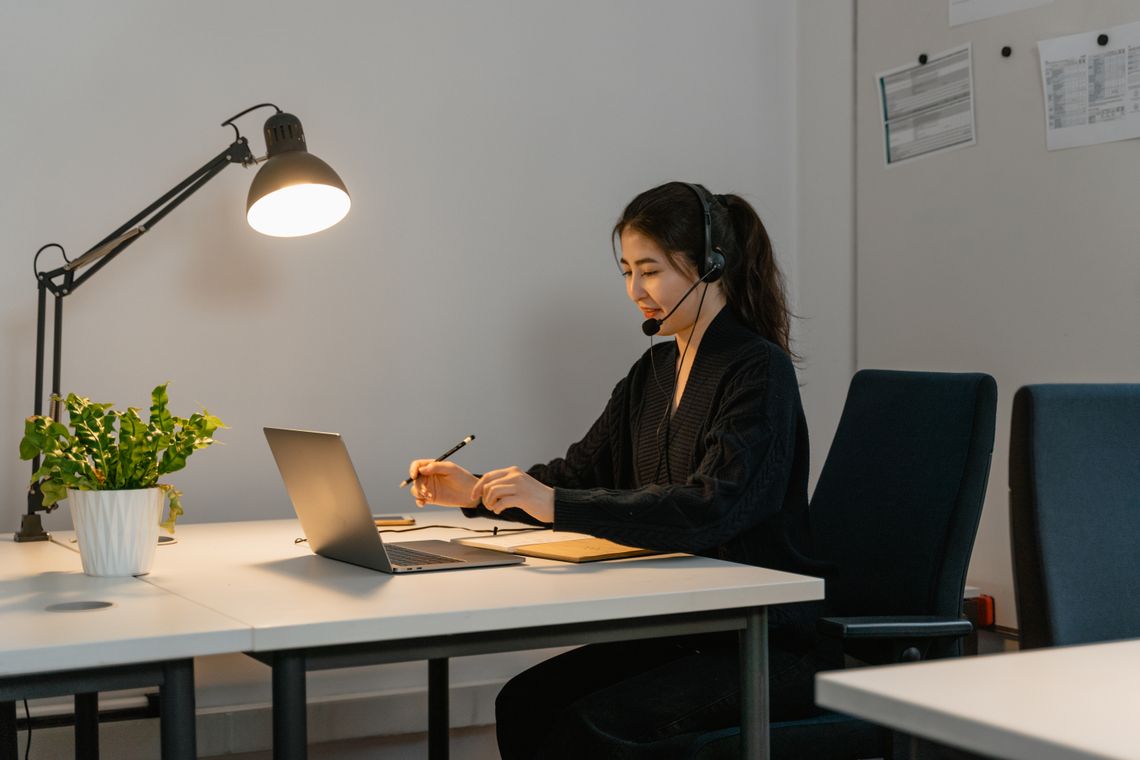 Customer support professional assisting from a laptop and headset
