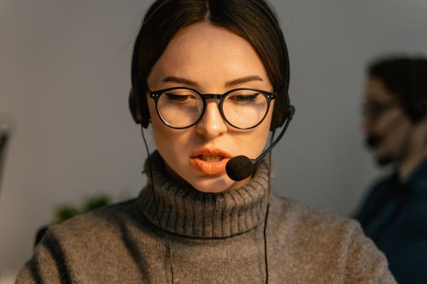 Virtual assistant wearing a headset during a research call in a low-lit office