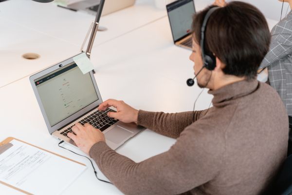 Person using laptop with live chat support on screen
