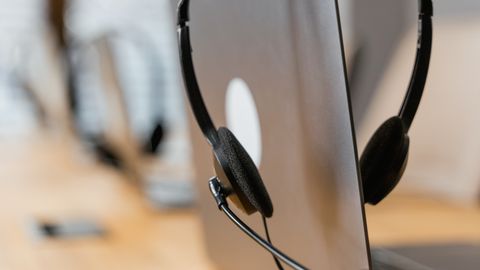 Close-up of a headset resting on a laptop, symbolizing efficient work environment technology.