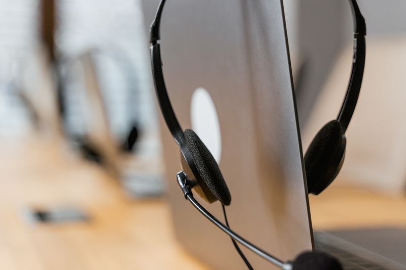 Auriculares de atención técnica junto a laptop