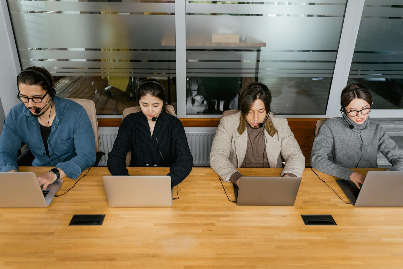 Team diversificato che lavora su laptop in un ufficio moderno