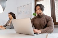 Man in Brown Sweater Working as a Call Center Agent