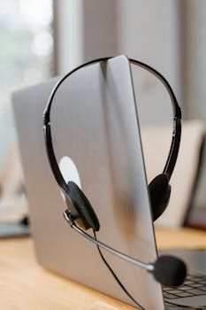 Headset on a laptop symbolizes remote work and communication efficiency.
