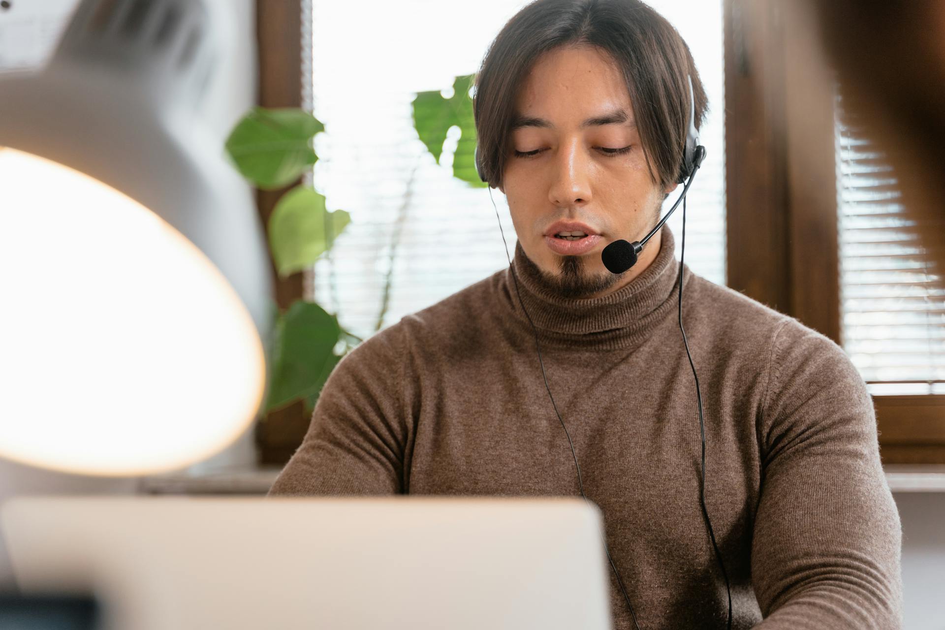 Call center operator with a headset working from home office, focused on customer support.