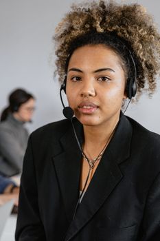 Professional woman in a call center wearing a headset, providing customer service.