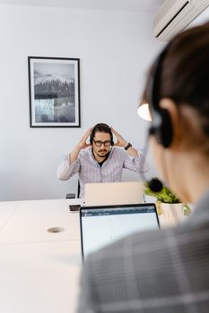Professional man with headset in modern office call center providing customer support
