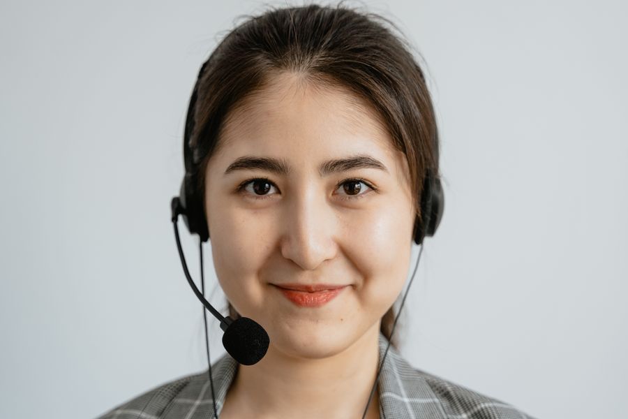 Smiling on-demand specialist wearing a headset at a computer