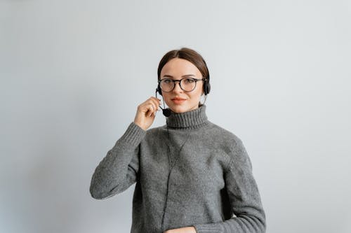 Photo of a Woman Holding the Microphone of Her Headset