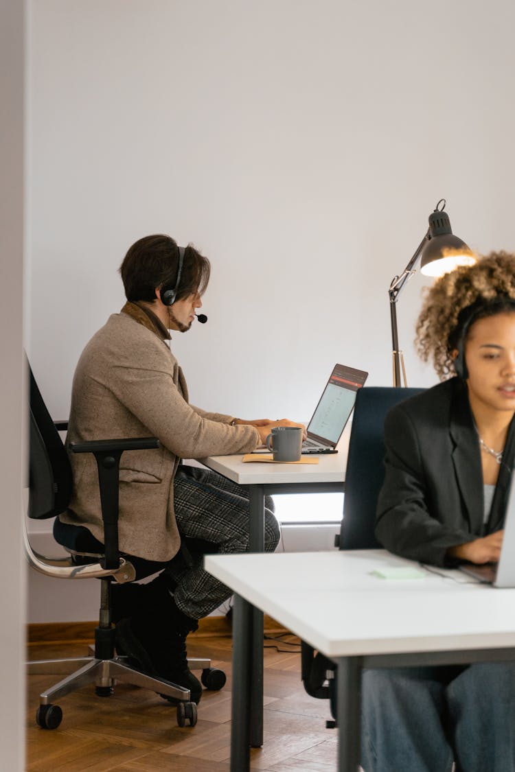 A Man In A Brown Blazer Working In An Office