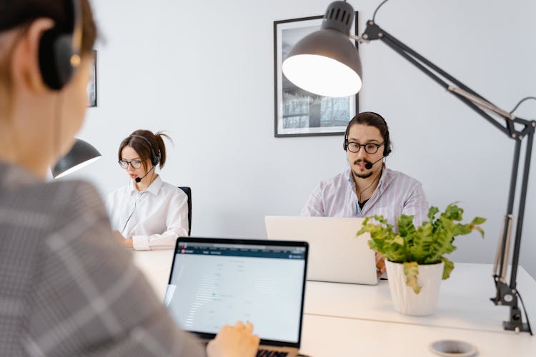 Group Of People Wearing Black Headphones With Mic While Using Laptop