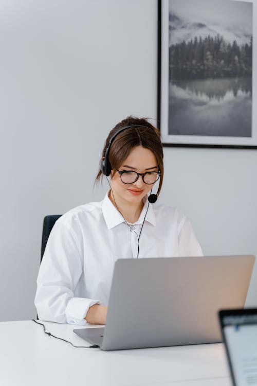 Woman in a White Dress Shirt Working on Her Laptop