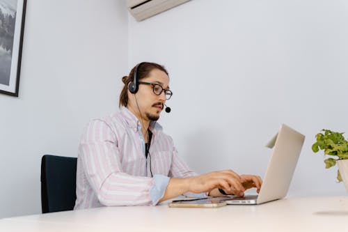 Free Photo of an Agent with Facial Hair Typing on His Laptop Stock Photo