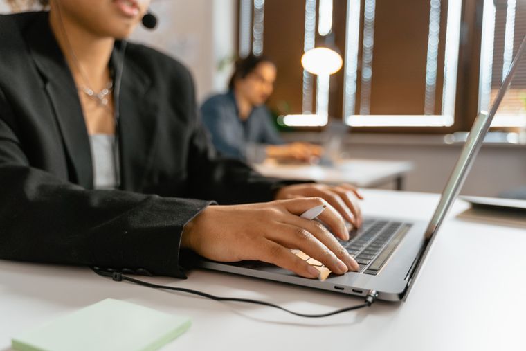 Support agents working on laptops in an office — photo by MART PRODUCTION on Pexels