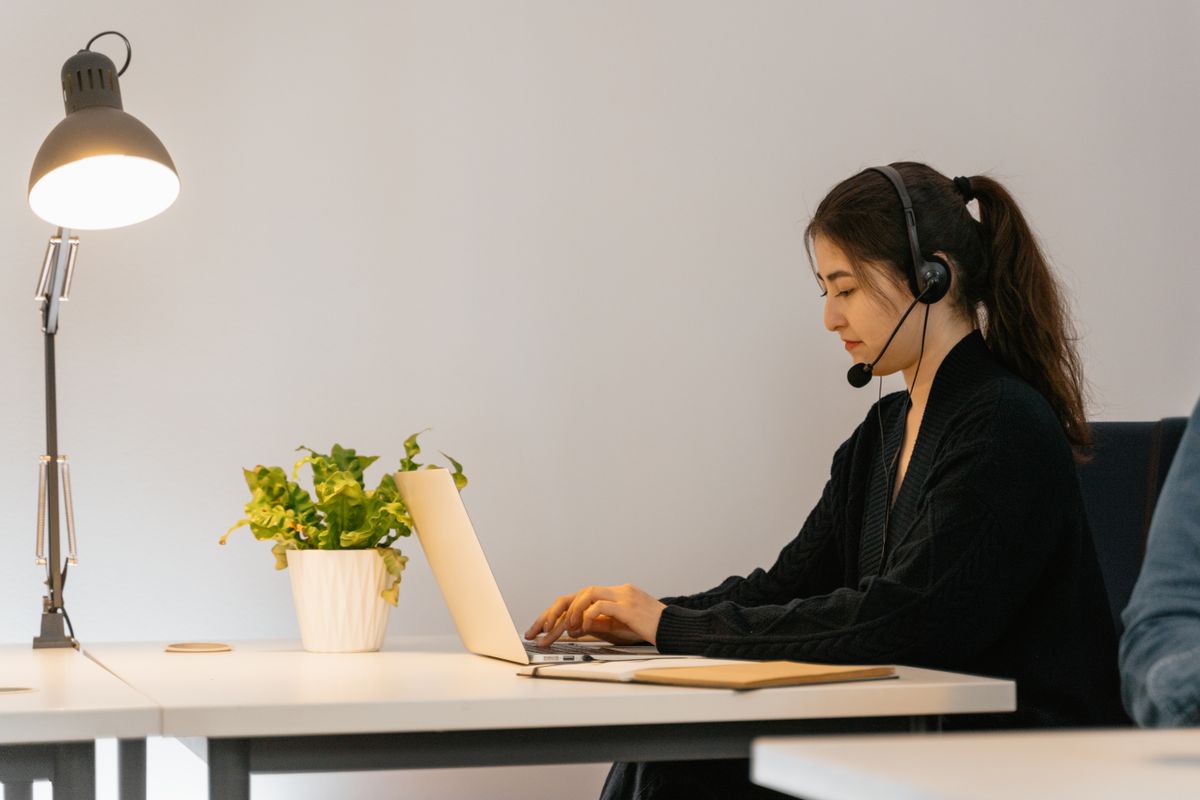 A virtual assistant working with a headset and laptop