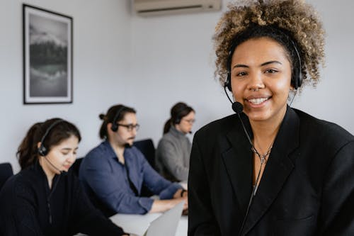 Photo of a Woman with Curly Hair Wearing a Black Headset