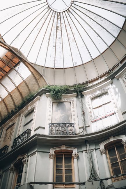 Low angle of old building passage with windows in inner patio under glass dome in daylight