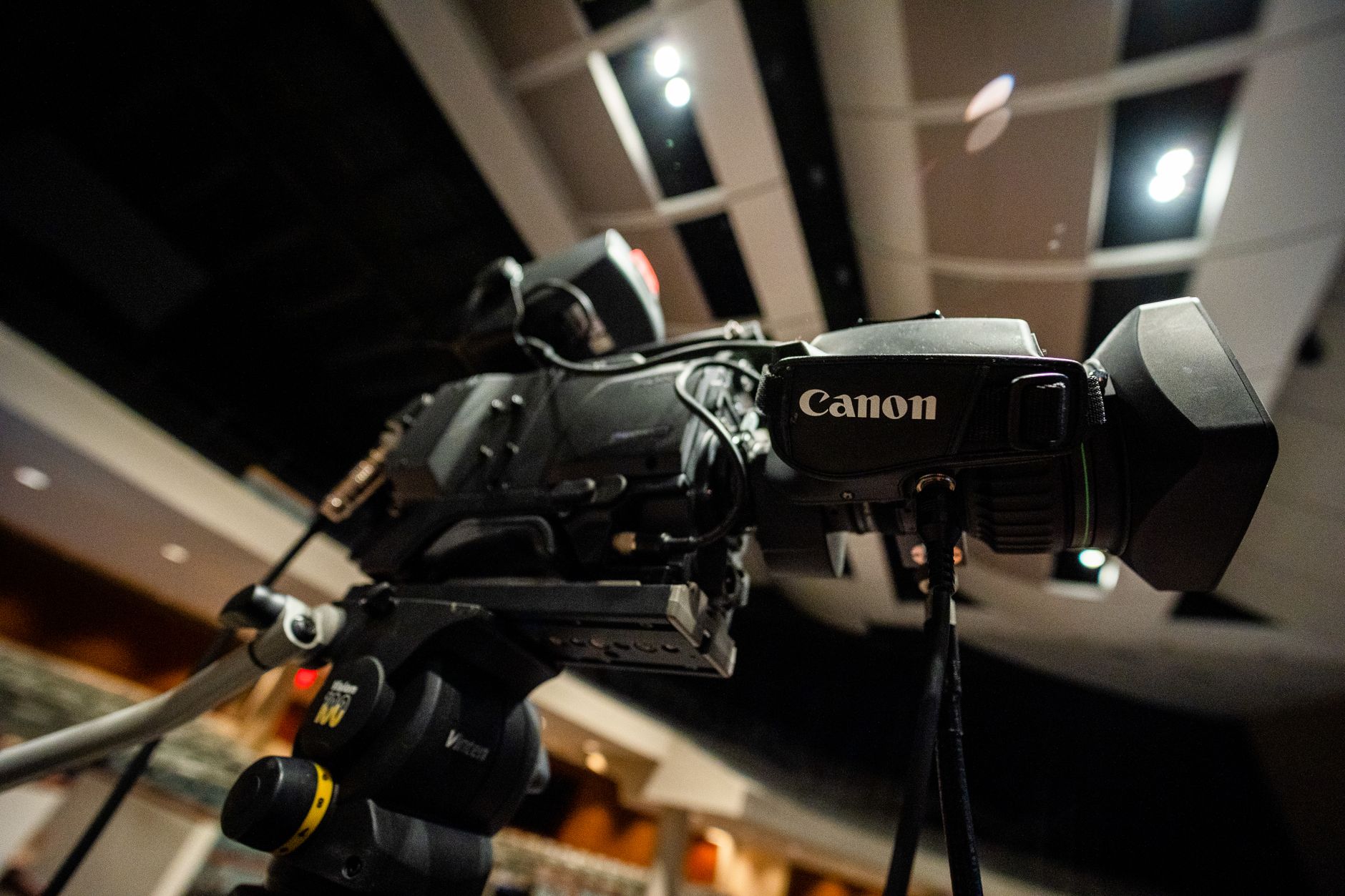 From below of professional black video camera for filming video placed in modern room
