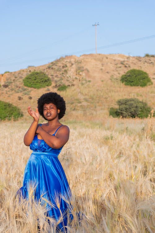 Woman in a Blue Dress Posing in a Grass Field